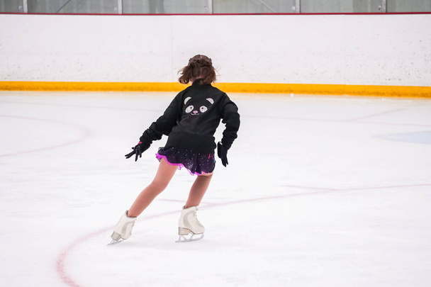 Little girl practicing before her figure skating competition at the indoor ice rink. - Photo, Image