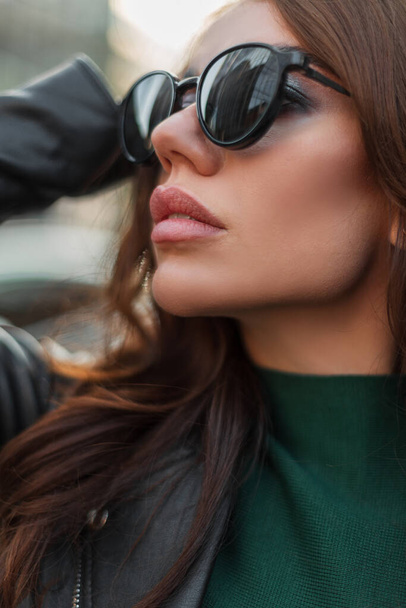Close-up moda kobiecy portret piękny stylowy cool kobieta z czystej skóry twarzy i seksowne usta w modne stylowe ubrania z mody czarne okulary przeciwsłoneczne w mieście - Zdjęcie, obraz