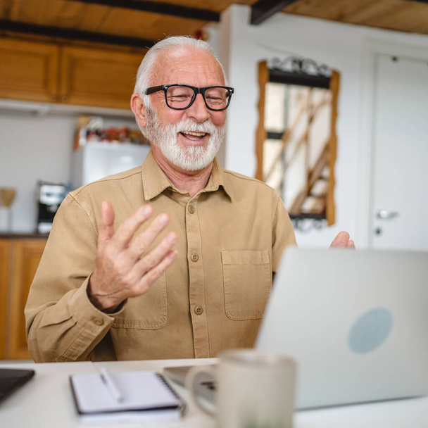 Vanhempi valkoihoinen mies käyttää kannettavaa tietokonetta soittamaan videopuhelun kotona - Valokuva, kuva