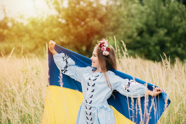 Ukraines Independence Flag Day. Constitution day. Ukrainian child girl in embroidered shirt vyshyvanka with yellow and blue flag of Ukraine in field. flag symbols of Ukraine. Kyiv, Kiev day - Fotografie, Obrázek