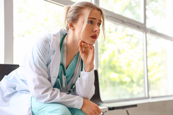 Dottore donna triste seduto in clinica - Foto, immagini