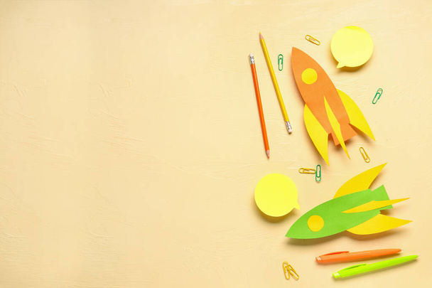 Foguetes de papel colorido com canetas, lápis e clipes em fundo bege - Foto, Imagem