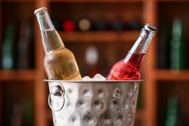 Bucket with bottles of cold beer in bar, closeup - Foto, afbeelding