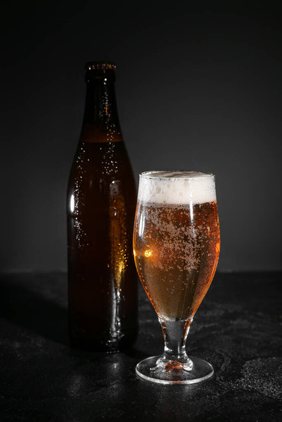 Bottle and glass of cold beer on dark background - Photo, Image