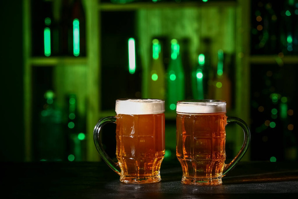 Tazas de cerveza fresca en la mesa en el bar - Foto, imagen