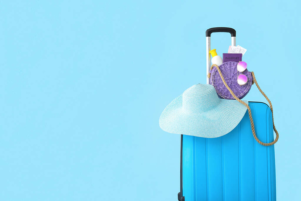 Valigia con passaporto, biglietti e accessori da spiaggia su sfondo blu. Concetto di viaggio - Foto, immagini
