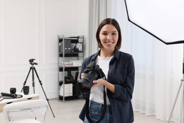 Young professional photographer with camera in photo studio, space for text - Fotografie, Obrázek