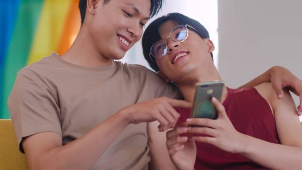 Šťastný gayové asijské pár tráví čas spolu v obývacím pokoji doma. - Fotografie, Obrázek
