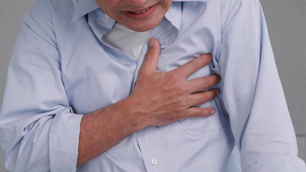 Aziatische man heeft pijn op de borst veroorzaakt door hartziekte. - Foto, afbeelding