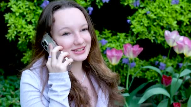 Portrét mladé ženy turistické mít vzdálenou konverzaci komunikovat pomocí chytrého telefonu. Dívka mluví po telefonu nečekané dobré zprávy klepy procházky v městské ulici. Životní styl města - Záběry, video