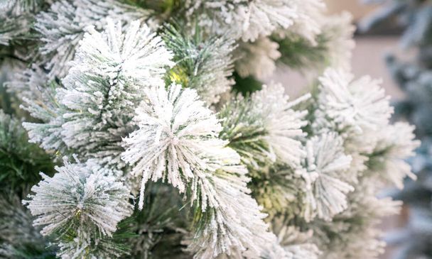 Christmas tree with artificial snow flakes, close up. White christmas concept. - Fotó, kép