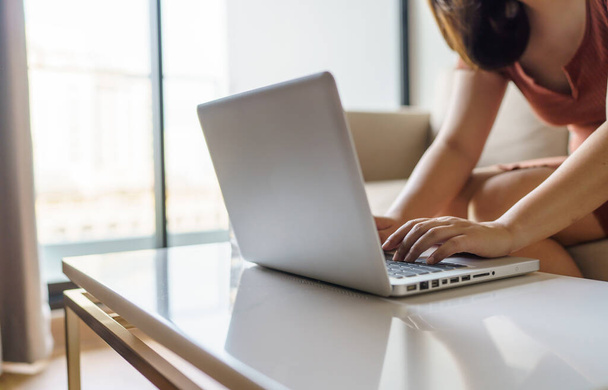женщина, использующая компьютер ноутбук для работы онлайн в гостиной - Фото, изображение