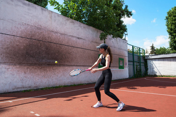 Young tennis girl is playing on the wall. Professional sport. - Foto, imagen