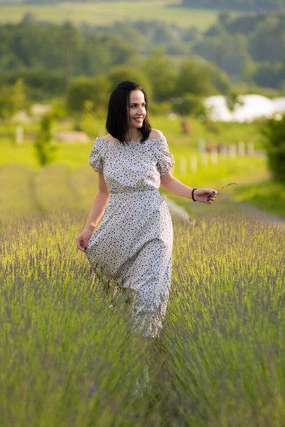 woman in white dress walking in a field of flowers - Fotó, kép