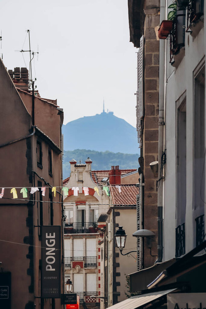 Decoratie die droogkleren nabootst aan de overkant van een straat in Clermont Ferrand, met de Puy de Dome vulkaan op de achtergrond - Foto, afbeelding