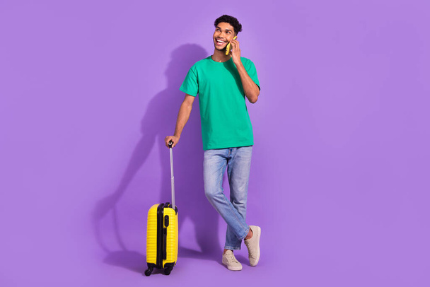 Full body photo of handsome man speak telephone hold suitcase isolated on violet color background. - Foto, Imagem