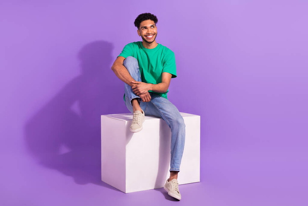 Full body photo of young handsome guy dream thoughts about next job sit platform box looking empty space isolated over purple background. - Foto, Imagen
