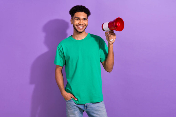 Photo of cheerful cool guy dressed green t-shirt holding loud speaker empty space isolated violet color background. - Fotografie, Obrázek