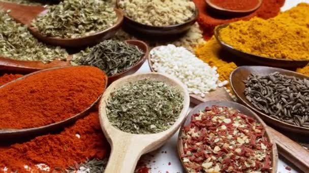 Fundo de especiarias. Especiarias de comida indiana e asiática em colheres e fundo escuro. Curry, pimenta, pimenta como ingredientes da cozinha indiana - Filmagem, Vídeo