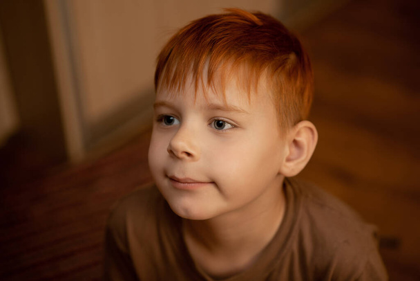 Red-haired young boy in thought, attention. - 写真・画像