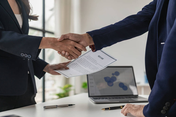 Job interview. Two businessmen shake hands to submit resume documents. HR manager shakes hands congratulating job candidates for successful job application close up pictures - Photo, Image