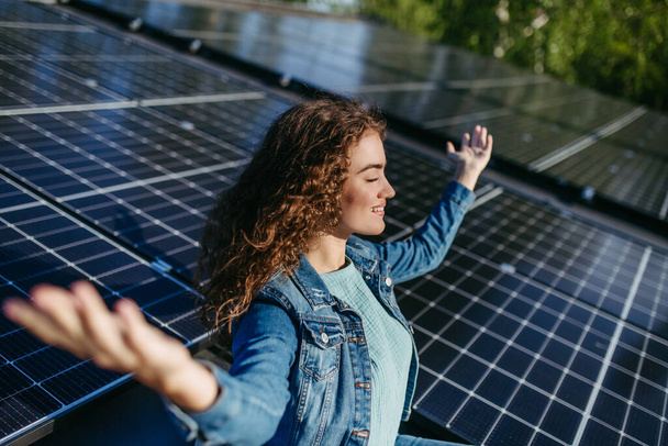Portrait of young woman, owner on roof with solar panels. - Foto, Imagen