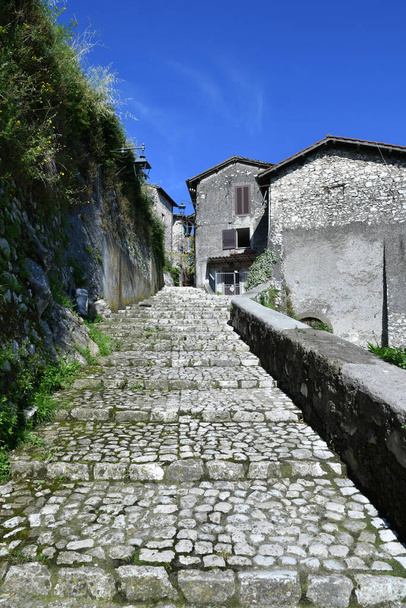 Ένας στενός δρόμος ανάμεσα στα παλιά σπίτια της Αρτένας, μια μεσαιωνική πόλη κοντά στη Ρώμη, Ιταλία. - Φωτογραφία, εικόνα