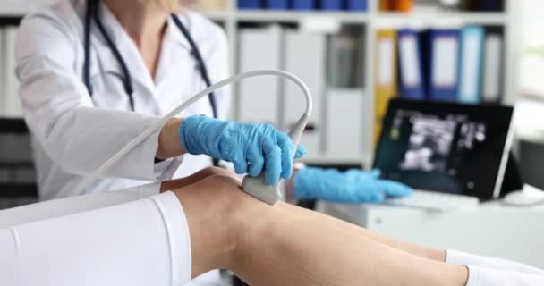 Γιατρός διεξάγει υπερηχογράφημα εξέταση του γόνατος του ασθενούς στην κλινική. Αρθρώσεις της άρθρωσης του γόνατος ή γονάρθρωσης έννοια - Πλάνα, βίντεο