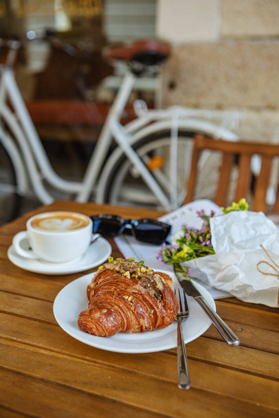 Śniadanie: Croissant z kawą i Magazine w Cafe - Zdjęcie, obraz