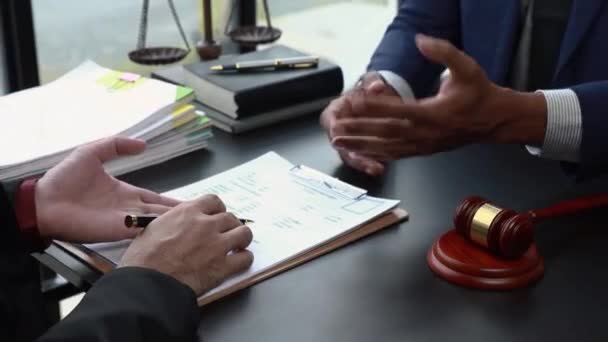 Advocaten die de verjaringstermijn lezen Overleg tussen mannelijke advocaten en zakelijke klanten, belasting- en juridische dienstverleners. - Video