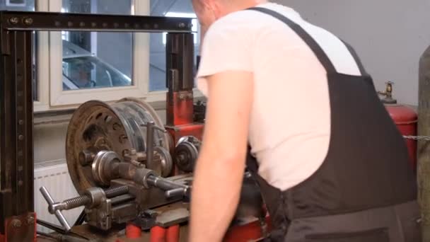 A car mechanic repairs a bent rim of a car. Damaged steel. Auto mechanic services. - Video, Çekim