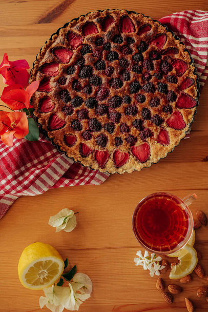 Flat lay of homemade blackberry and strawberry tart with Frangipane cream on the table  - Foto, afbeelding