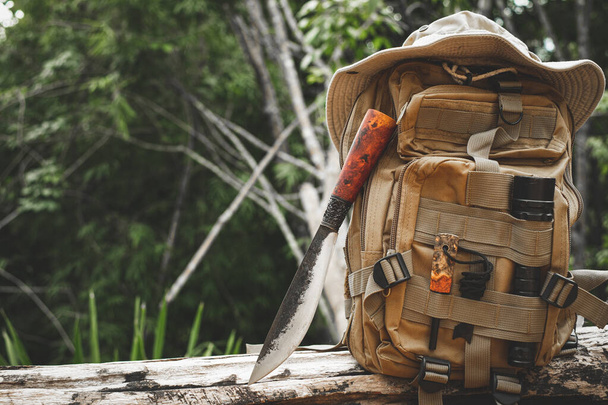 A knife backpack with equipment for survival in the forest on an old timber wooden - 写真・画像