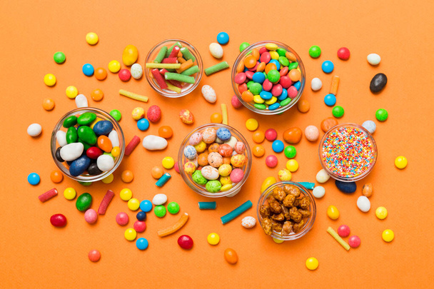 different colored round candy in bowl and jars. Top view of large variety sweets and candies with copy space. - Photo, Image