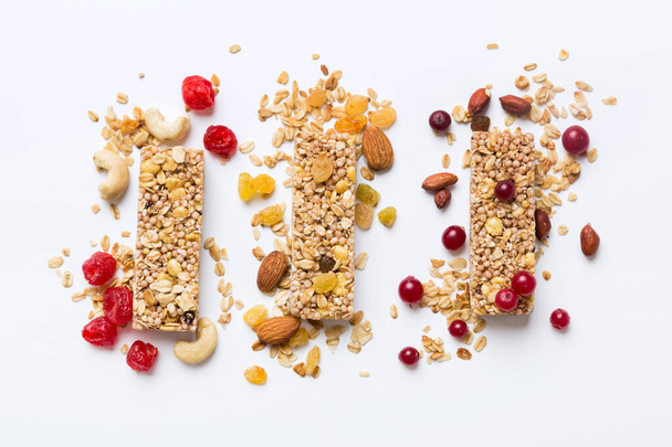 Various granola bars on table background. Cereal granola bars. Superfood breakfast bars with oats, nuts and berries, close up. Superfood concept. - Zdjęcie, obraz