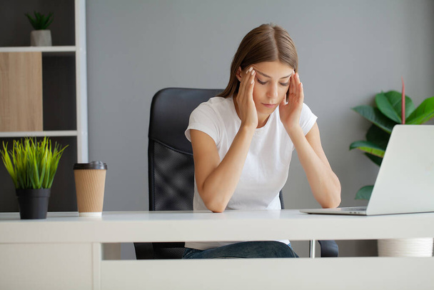 Žena masíruje spánky, trpí bolestí hlavy po počítačové práci. - Fotografie, Obrázek
