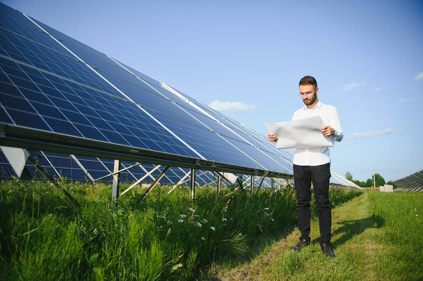 Solar power plant. Engineer on a background of photovoltaic panels. Science solar energy. - Zdjęcie, obraz