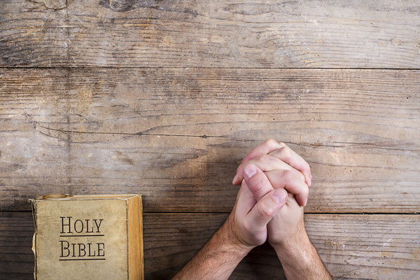 Hands of praying man with Bible - Фото, изображение