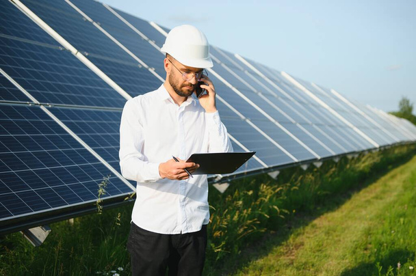 Male worker solar power plant on a background of photovoltaic panels - Fotó, kép