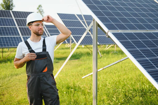 A handyman standing with solar panels - Fotó, kép