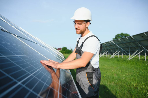 Male worker solar power plant on a background of photovoltaic panels - Valokuva, kuva