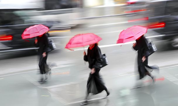 business people walking in the street on a rainy day motion blur - Foto, Imagen