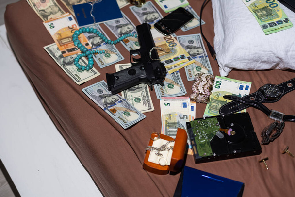 Money and weapons in crime lab for investigation, conceptual image. High quality photo - Photo, Image