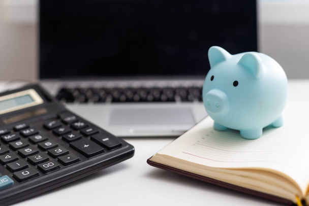Piggy Bank met laptop wat betekent geld verdienen online of internet business concepten. - Foto, afbeelding