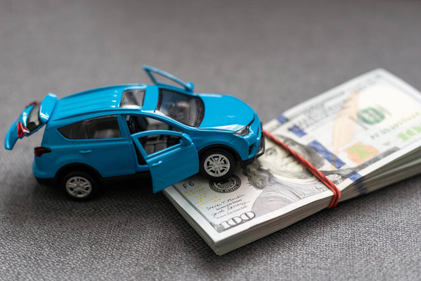 Auto en geld. concept van auto, Huur, autoverzekering, Speelgoed auto en geld over wit - Foto, afbeelding