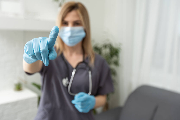 Жінка-лікар в гумових рукавичках показує жест, що тримає щось
 - Фото, зображення