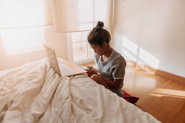 Asian woman working online business in her bedroom. - Foto, Imagen