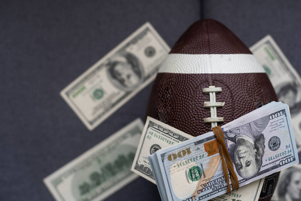 Money and rugby ball on gray background. Concept of sports bet. - 写真・画像
