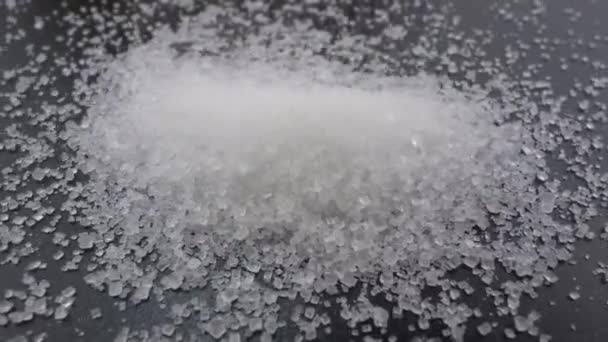 Zuckergranulat. Weißer Rohrzucker fällt auf schwarzem Hintergrund - Filmmaterial, Video