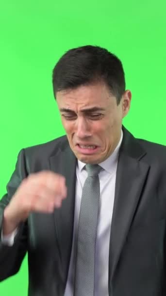 Verontrustende man met zwart haar in elegante pak aanraken gezicht en huilen terwijl geïsoleerd op chroma sleutel in lichte studio - Video